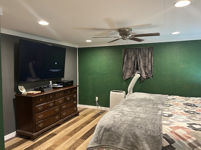 bedroom featuring ceiling fan, light hardwood / wood-style floors, and ornamental molding