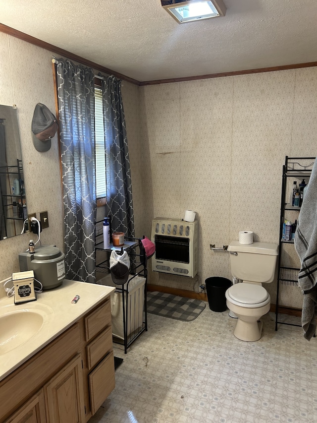 bathroom with a textured ceiling, vanity, crown molding, toilet, and heating unit