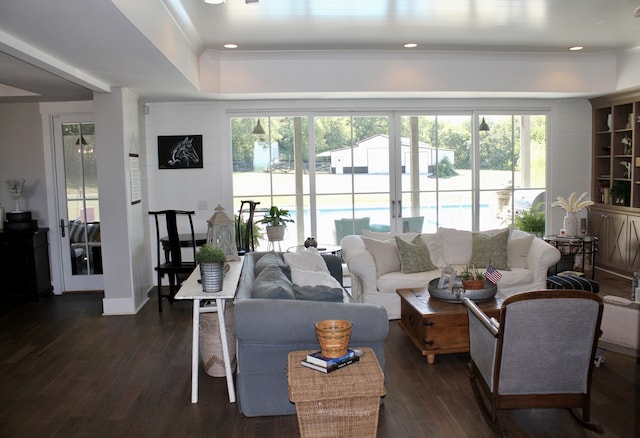 living room with dark hardwood / wood-style flooring and a healthy amount of sunlight