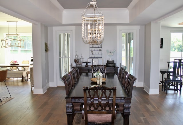 dining area featuring a tray ceiling, dark hardwood / wood-style floors, and a chandelier