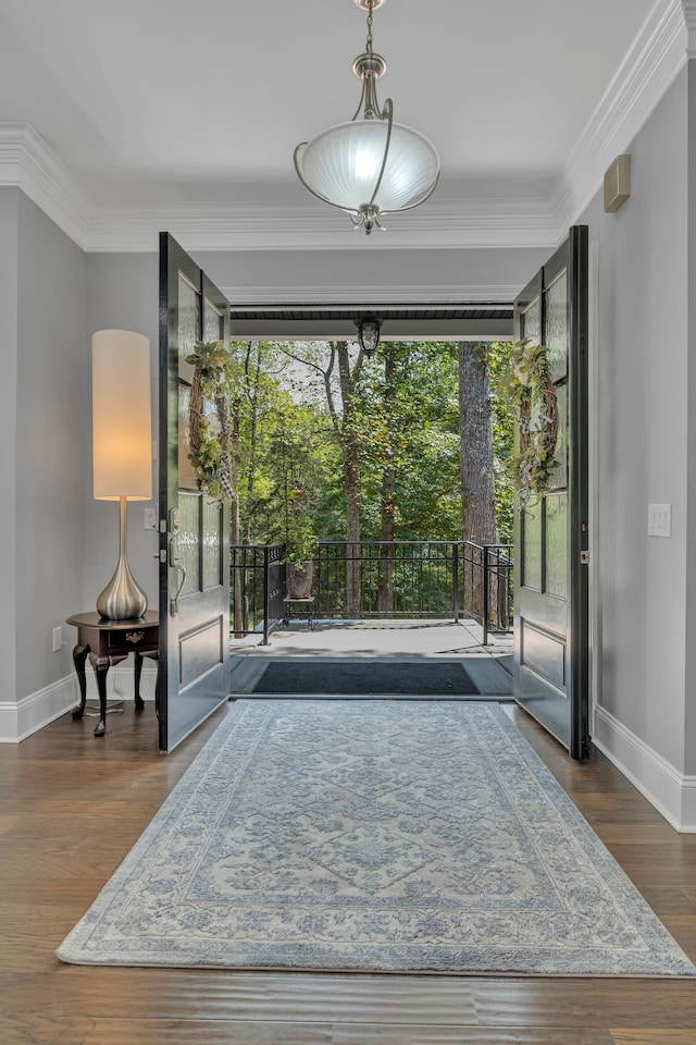 doorway to outside with a notable chandelier, dark hardwood / wood-style flooring, and crown molding