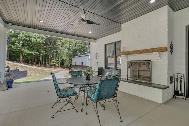 view of patio / terrace featuring an outdoor brick fireplace and ceiling fan