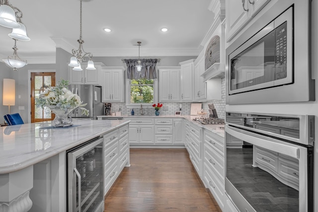 kitchen with an inviting chandelier, light stone countertops, beverage cooler, stainless steel appliances, and white cabinets