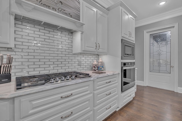 kitchen featuring custom range hood, appliances with stainless steel finishes, crown molding, hardwood / wood-style flooring, and white cabinetry