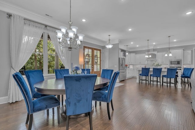 dining space with a chandelier, dark hardwood / wood-style flooring, and crown molding