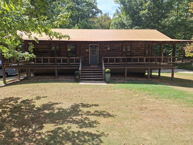 450 Pinson Ln, Big Sandy, TN 38221 - view of front of house featuring a front yard, log siding, and metal roof