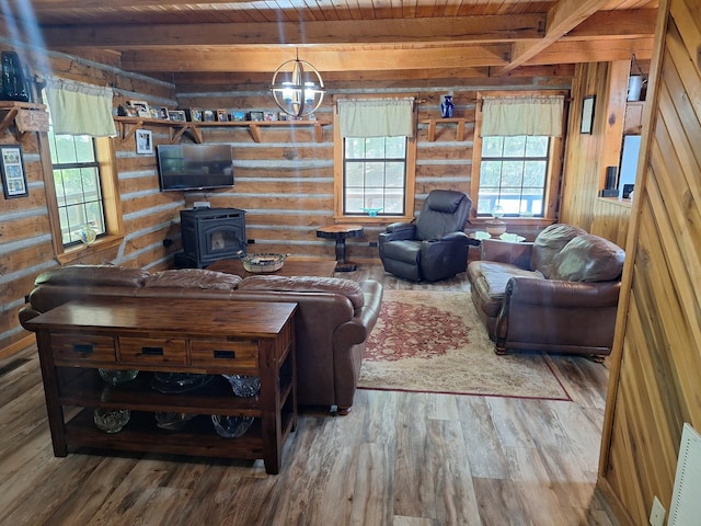 450 Pinson Ln, Big Sandy, TN 38221 - living area featuring wood finished floors, wooden walls, wood ceiling, a wood stove, and beam ceiling