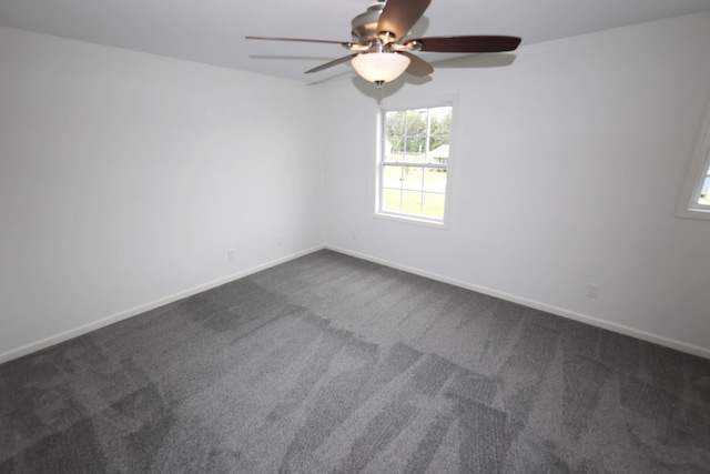 empty room with dark colored carpet and baseboards