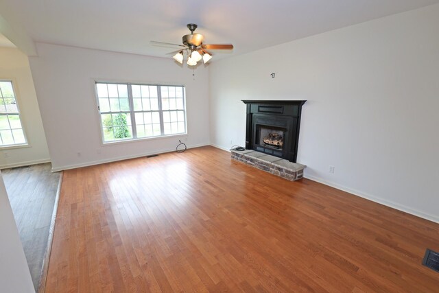 unfurnished living room featuring ceiling fan and hardwood / wood-style floors