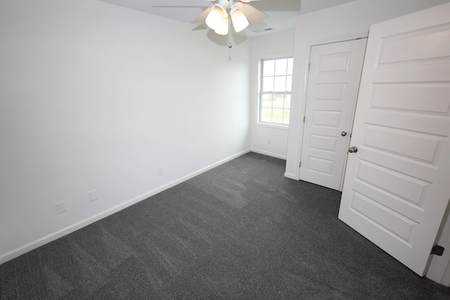 unfurnished bedroom featuring a ceiling fan, dark colored carpet, visible vents, and baseboards