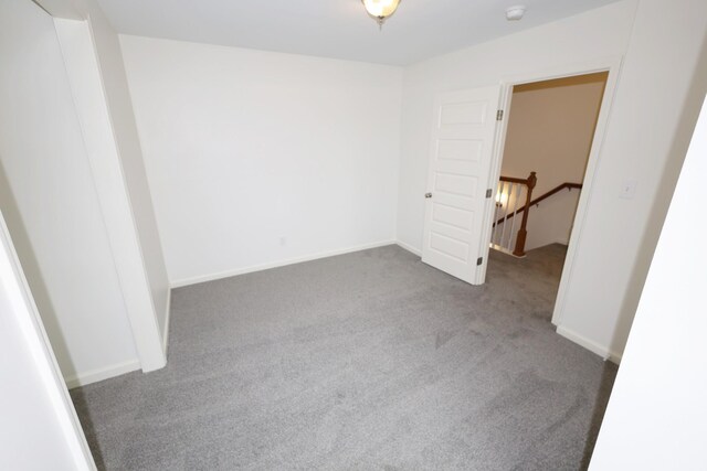 carpeted empty room featuring baseboards