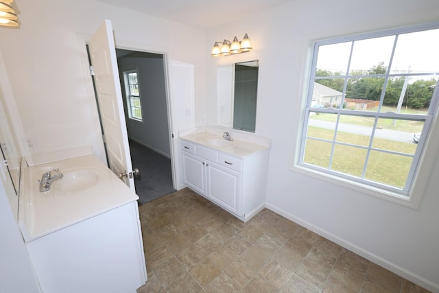 full bathroom with plenty of natural light, vanity, and baseboards