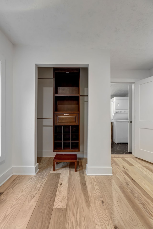 interior space with stacked washer / dryer and light wood-type flooring