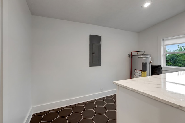 kitchen with light stone countertops, electric panel, and electric water heater