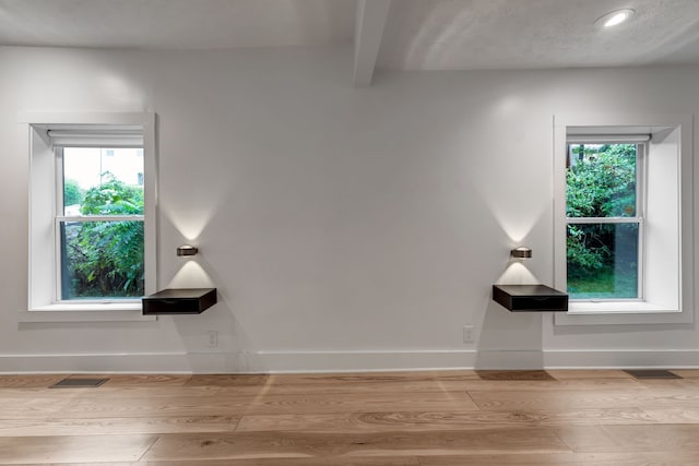 interior space featuring beamed ceiling and hardwood / wood-style floors