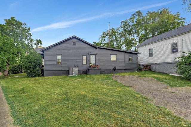 rear view of house featuring central AC and a yard