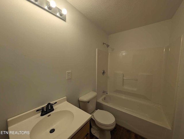 full bathroom featuring hardwood / wood-style flooring, a textured ceiling, shower / washtub combination, toilet, and vanity