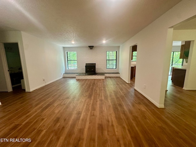 unfurnished living room with a wealth of natural light, a fireplace, and a textured ceiling