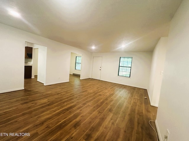 spare room with plenty of natural light and dark hardwood / wood-style floors