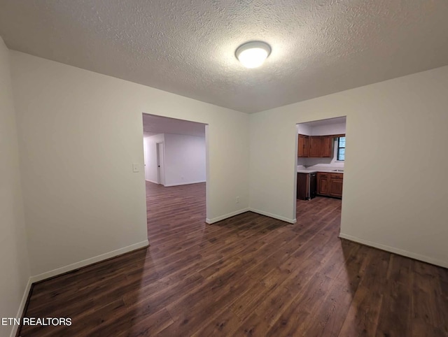 unfurnished room featuring a textured ceiling and dark hardwood / wood-style floors