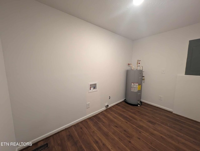 empty room with electric panel, dark hardwood / wood-style floors, and electric water heater