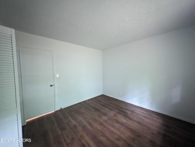 unfurnished room with dark hardwood / wood-style floors