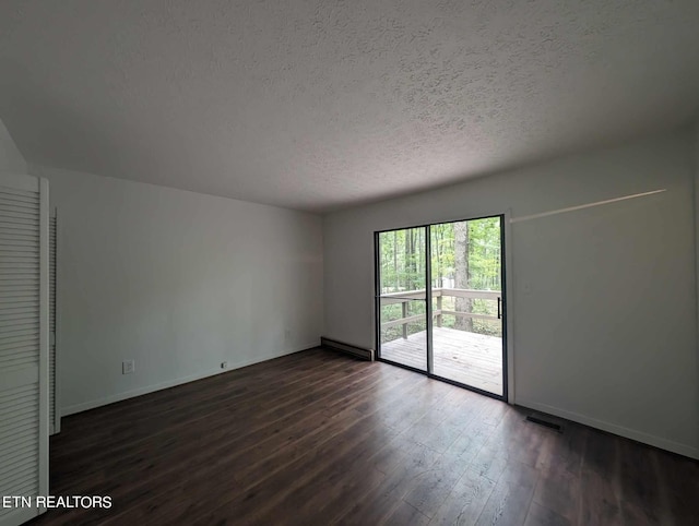 unfurnished room with a textured ceiling, dark wood-type flooring, and baseboard heating