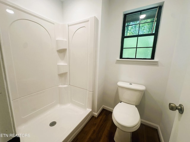 bathroom with a shower, toilet, and wood-type flooring