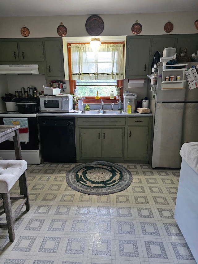 kitchen featuring green cabinets, black dishwasher, stainless steel refrigerator, and sink