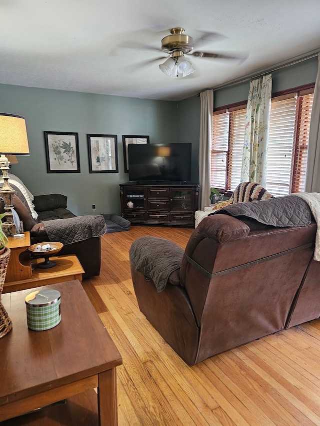 living room featuring light wood-type flooring and ceiling fan