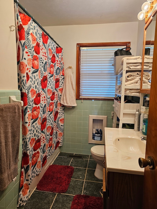 bathroom with vanity, toilet, curtained shower, and tile walls