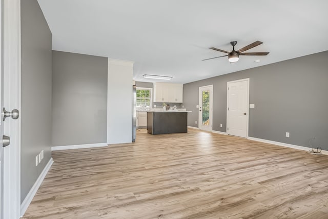 unfurnished living room featuring ceiling fan and light hardwood / wood-style floors