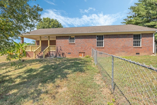 rear view of property featuring a yard