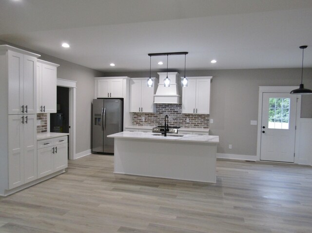 kitchen with light wood-type flooring, stainless steel fridge, white cabinetry, and custom exhaust hood