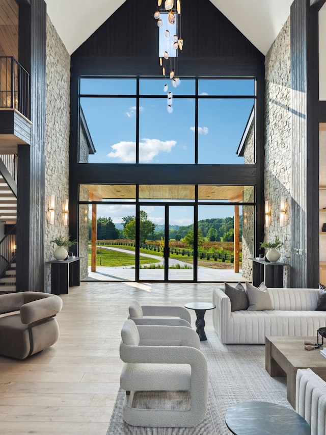 living room featuring wooden walls, hardwood / wood-style floors, and high vaulted ceiling