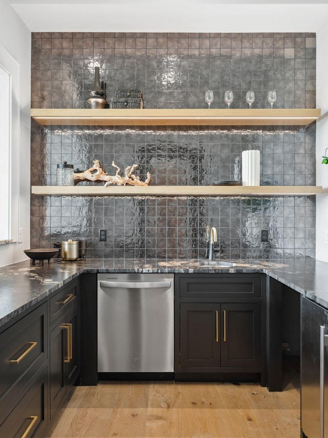 bar featuring dishwasher, decorative backsplash, light hardwood / wood-style flooring, and sink