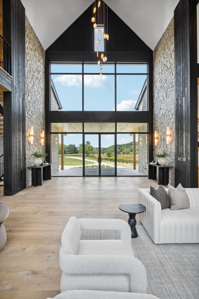 living room with hardwood / wood-style flooring, high vaulted ceiling, and a chandelier