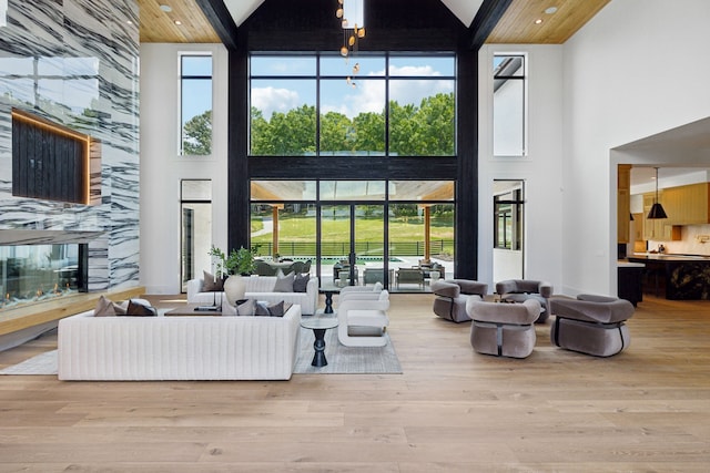 living room featuring a fireplace, high vaulted ceiling, and light hardwood / wood-style floors