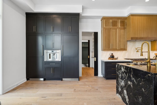 kitchen with oven, light hardwood / wood-style flooring, and sink