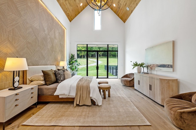 bedroom with wood ceiling, light wood-type flooring, a high ceiling, and access to outside