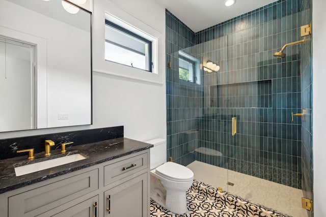 bathroom with tile patterned flooring, vanity, toilet, and an enclosed shower