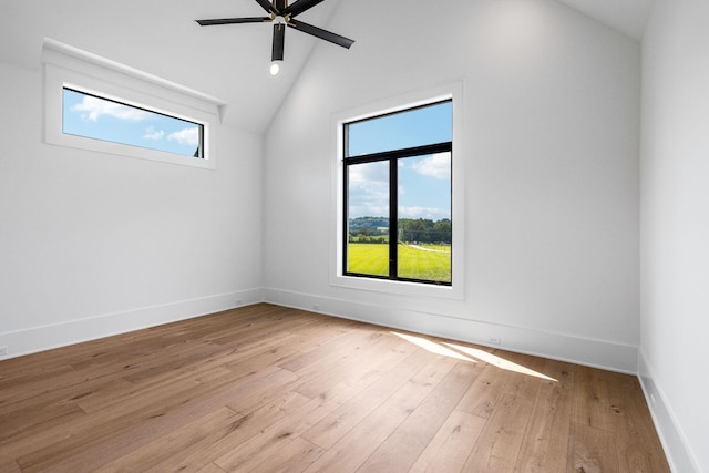 spare room featuring light hardwood / wood-style flooring, vaulted ceiling, and ceiling fan