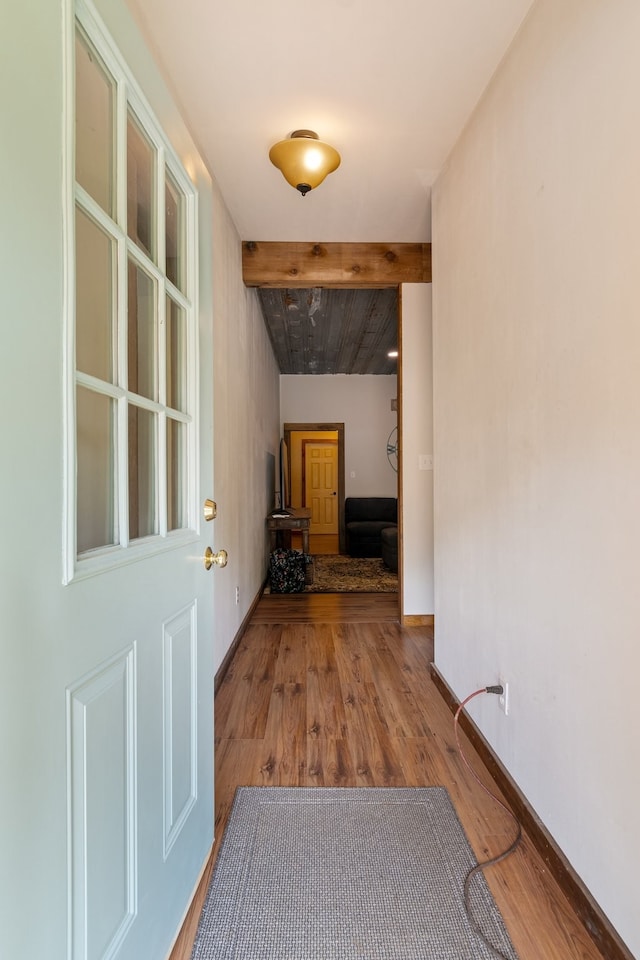 corridor with wood-type flooring and beam ceiling