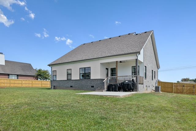 rear view of property featuring central AC unit, a yard, and a patio