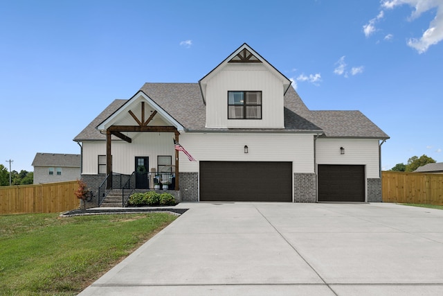 view of front of home with a porch, a garage, and a front lawn