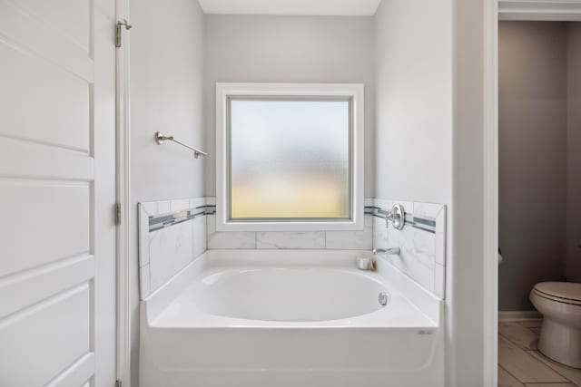 bathroom featuring toilet, a tub, and tile patterned flooring