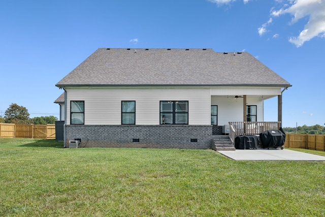 back of property with a yard, ceiling fan, and a patio