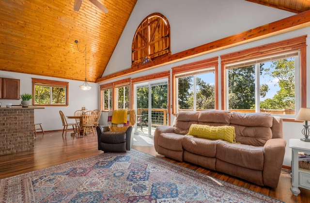 living room with high vaulted ceiling, wood finished floors, and baseboards