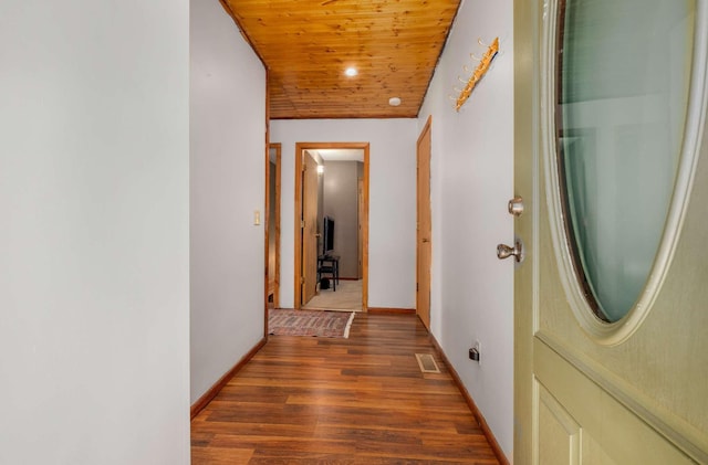 hall featuring wooden ceiling, visible vents, baseboards, and wood finished floors