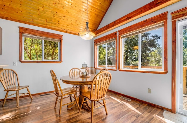 dining space with vaulted ceiling, wood finished floors, and visible vents